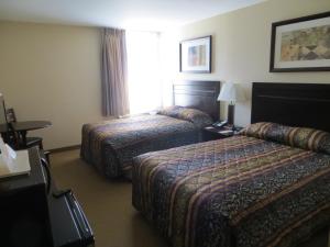 A bed or beds in a room at New Lodge Winnipeg