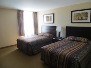 a hotel room with two beds and a window at New Lodge Winnipeg in Winnipeg
