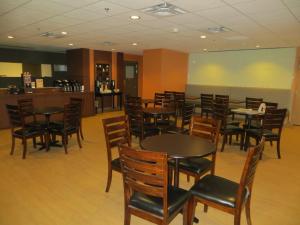 a restaurant with tables and chairs in a room at New Lodge Winnipeg in Winnipeg