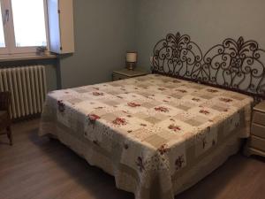 una camera con un letto con una trapunta sopra di La Casa nel Verde a Biella