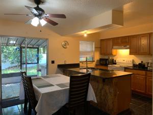 a kitchen with a table and a ceiling fan at House 3br 1-bath, 8-min from Indian Rocks Beach, nice park thru back gate in Largo