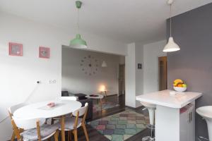 cocina y comedor con mesa blanca y sillas en Apartment Amra, en Visoko