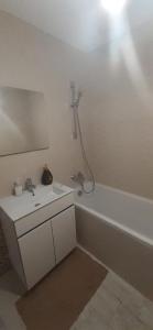 a white bathroom with a sink and a bath tub at Apartament central. Bloc nou. in Bacău