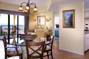 a dining room and living room with a table and chairs at Club Wyndham Sea Gardens in Pompano Beach