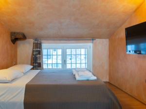 a bedroom with a large bed with a tv on the wall at Bea Ducale in Vigevano