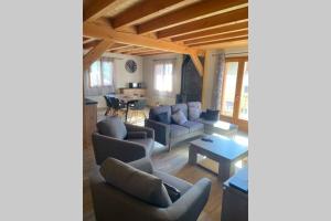 a living room with couches and a table at Charmant logement à Serre Chevalier in Puy-Saint-Pierre