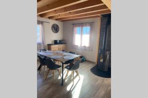a dining room with a table and chairs and a stove at Charmant logement à Serre Chevalier in Puy-Saint-Pierre