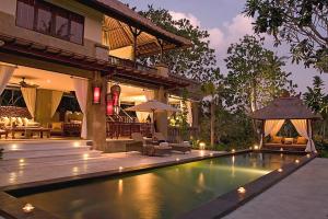 a house with a swimming pool in front of a house at Villa Teresa in Canggu