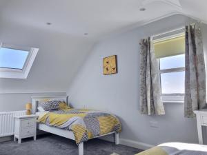 1 dormitorio con cama y ventana en Cranfield Cottage by the Sea 4 star NITB approved en Kilkeel