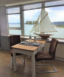 シュレースヴィヒにあるFerienwohnung-Seemoeweの木製テーブル(室内に帆船付)