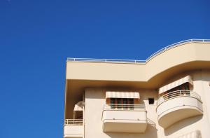 un edificio con 2 balcones y un cielo azul en Hotel Capri & Residence, en Lido di Camaiore