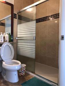a bathroom with a toilet and a glass shower at Deer Lake Home in Burnaby
