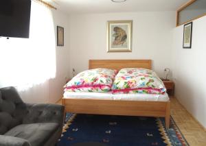 een slaapkamer met een bed met kussens en een bank bij Homely Apartment in the Center with Garden View in Gmunden