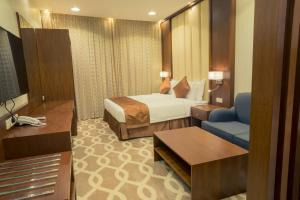 a hotel room with a bed and a blue chair at 92 - وحدات فندقية - in Unayzah