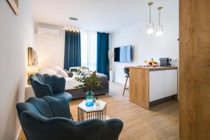 Il comprend un salon avec un canapé et deux chaises ainsi qu'une cuisine. dans l'établissement RC Apartment, à Split