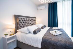 - une chambre avec un grand lit et des rideaux bleus dans l'établissement RC Apartment, à Split