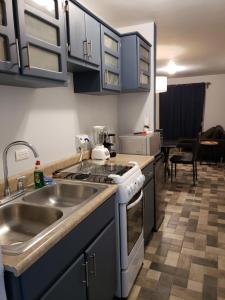 a kitchen with a sink and a stove at Casa Raquelina, casa habitacional in Ensenada