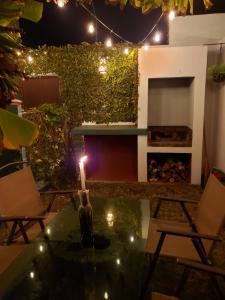 a patio at night with a candle and chairs at Casa Raquelina, casa habitacional in Ensenada
