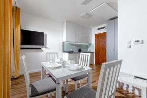 ein Esszimmer mit einem weißen Tisch und Stühlen in der Unterkunft Apartament 'Niechorze' in Niechorze