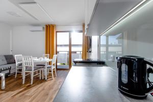 ein Wohnzimmer mit einem Tisch, Stühlen und einem Mixer in der Unterkunft Apartament 'Niechorze' in Niechorze