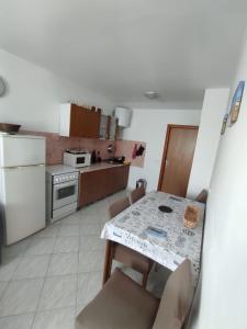 a kitchen with a table and chairs and a kitchen with a stove at Apartments "Mulo" beachfront in Vrsi
