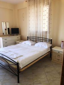 a bedroom with a bed and a tv and a mirror at The Sunset Villa Leven in Vlorë
