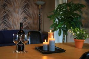 a table with a bottle of wine and two candles at De Kopstoof in Lekkerkerk +39 photos