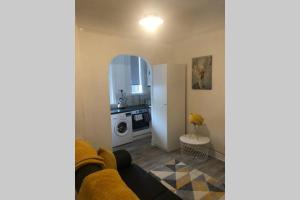 a living room with a couch and a kitchen at One bedroom Flat on the banks of Loch Lomond in Alexandria