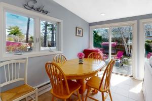ein Esszimmer mit einem Holztisch und Stühlen in der Unterkunft Cape Cod Beach Cottage in Dennis