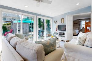 ein Wohnzimmer mit weißen Sofas und einem Fernseher in der Unterkunft Cape Cod Beach Cottage in Dennis