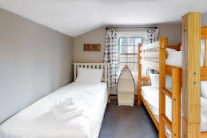 1 Schlafzimmer mit 2 Etagenbetten und einer Leiter in der Unterkunft Cape Cod Beach Cottage in Dennis