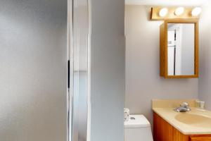 ein Badezimmer mit Waschbecken, Toilette und Spiegel in der Unterkunft Cape Cod Beach Cottage in Dennis + 19 Fotos