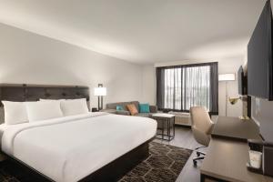 ドーサンにあるLa Quinta inn & suites by Wyndham Dothanの大きなベッドとリビングルームが備わるホテルルームです。