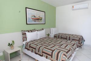ein Schlafzimmer mit einem Bett und einem Wandgemälde in der Unterkunft Pousada Mirante da Praia in São Miguel do Gostoso