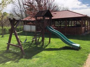 a playground with a slide and a gazebo at Kiscsere Vendégház in Kállósemjén