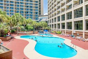 una piscina en un hotel con gente nadando en ella en Beach Cove Bungalow, en Myrtle Beach 15 fotos más