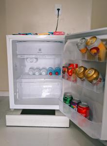 an open refrigerator filled with drinks and soda cans at Hotel Flor de Lótus II in Santa Isabel do Pará