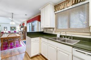 eine Küche mit weißen Schränken und einem Waschbecken und einem Tisch in der Unterkunft 460 Oceanwoods Cottage in Kiawah Island + 20 Fotos