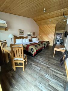 a bedroom with a large bed and a wooden ceiling at The Longhorn Ranch Resort Lodge & RV Park in Dubois