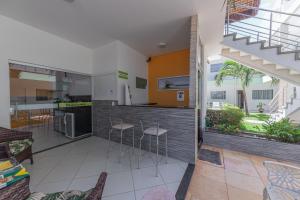 cocina y sala de estar con encimera y taburetes en Pousada Mirante da Praia, en São Miguel do Gostoso