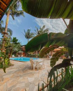 a patio with a table and chairs next to a pool at Pousada Chaday in Imbituba