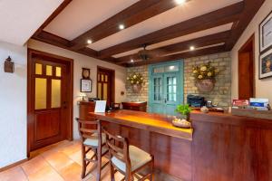 a kitchen with a bar with two chairs at a counter at Hotel Villa Therese in Port-au-Prince