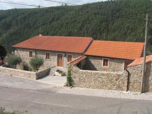 una casa de piedra con techo naranja en una calle en ACOLINA, en Aguda