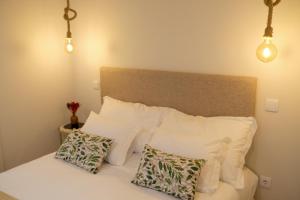 - une chambre dotée d'un lit avec des oreillers et des lumières blancs dans l'établissement Adega Floresta Residence, à Porto