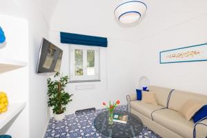 a living room with a couch and a tv at Villa Fortuna in Positano