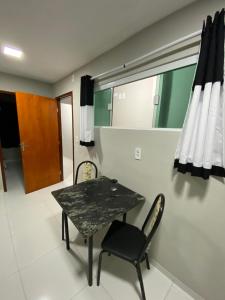 a dining room with a table and two chairs at Ap no campo dos velhos com ar in Sobral