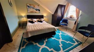 1 dormitorio con cama y alfombra azul en Złota Regalinda & Spa, en Międzyzdroje