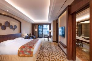 a hotel room with a large bed and a desk at Grand Metropark Longxi Conference Center Beijing in Beijing