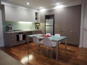 a kitchen with a table and chairs in a room at PierPoint 401 in Geelong