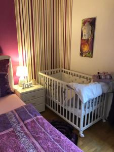 a baby bedroom with a crib and a table with a lamp at Haus Zissi in Burg-Reuland